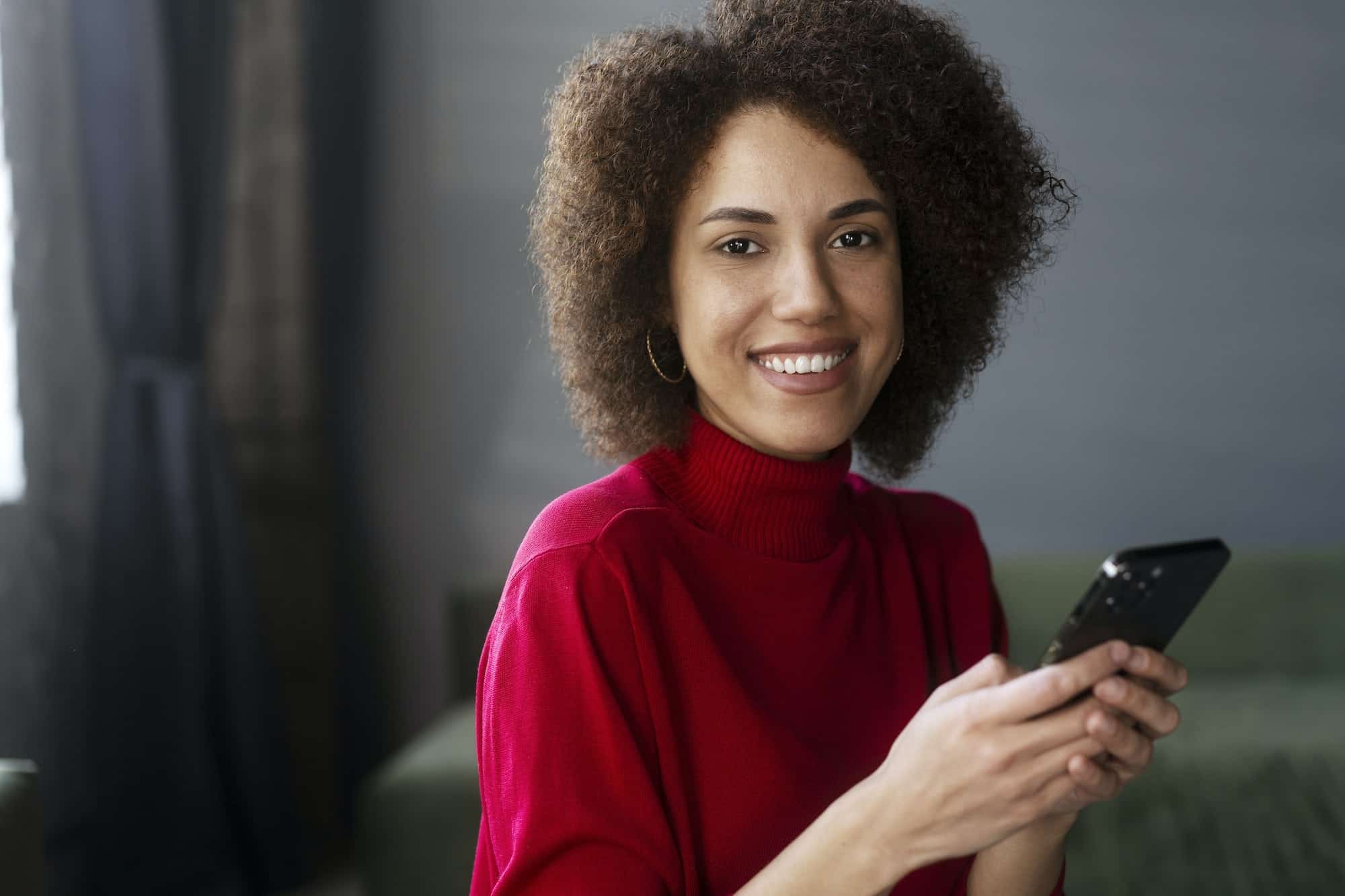 african-american-woman-in-red-casual-attire-using-mobile-phone-working-online-text-messaging.jpg